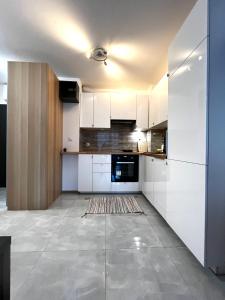 a kitchen with white cabinets and a tile floor at Downtown Apartment in Krakow