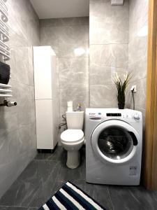 a bathroom with a washing machine and a toilet at Downtown Apartment in Krakow