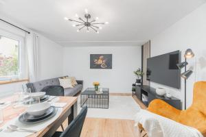a white living room with a table and a couch at Lemon Suites: Traumhaus in Filderstadt in Filderstadt