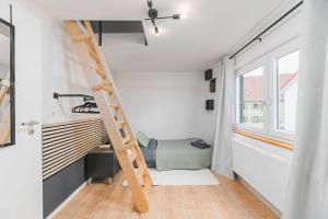 een stapelbed in een kleine kamer met een ladder bij Lemon Suites: Traumhaus in Filderstadt in Filderstadt