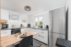 a kitchen with a wooden table and a refrigerator at Lemon Suites: Traumhaus in Filderstadt in Filderstadt