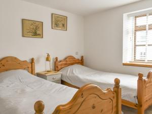 a bedroom with two beds and a window at Rose Cottage in Abbotsham