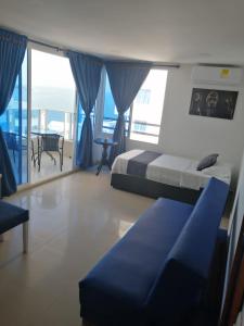 um quarto com uma cama, um sofá e uma varanda em Ocean blue Ed Conquistador em Cartagena das Índias