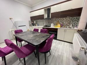 une cuisine avec une table et des chaises violettes dans l'établissement Premium VILLA (LUXURY Mansion), à Şamaxı