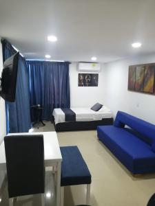 Habitación con 2 camas, TV y sofá. en Ocean blue Ed Conquistador, en Cartagena de Indias