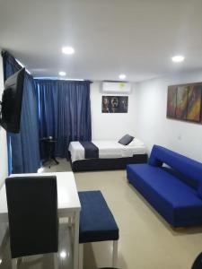 a room with two beds and a tv and a couch at Ocean blue Ed Conquistador in Cartagena de Indias