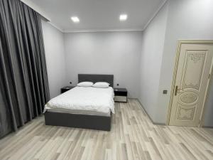 a white bedroom with a bed and a door at Premium VILLA (LUXURY Mansion) in Şamaxı