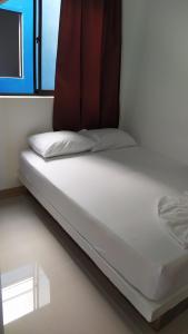 a bed in a room next to a window at HOTEL CASCADA PLAZA in Santa Fe de Antioquia