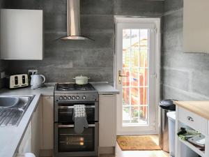 a kitchen with a stove and a sink at Kittys Cottage in Girvan