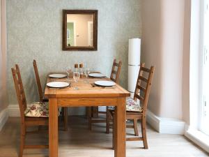 a wooden table with chairs and a mirror at Kittys Cottage in Girvan