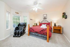 a bedroom with a bed and a chair and a ceiling fan at Great Smoky Mountain Get-Away in Pigeon Forge