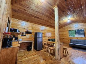 Cabaña de madera con cocina y sala de estar. en Cabaña en Vivero, Dota, Jardin en Jardín