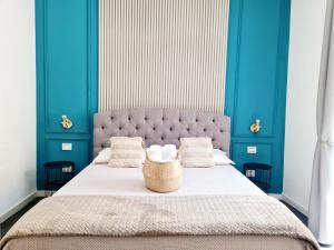 a bedroom with a large bed with blue walls at Lena's Suites Bari Vecchia in Bari