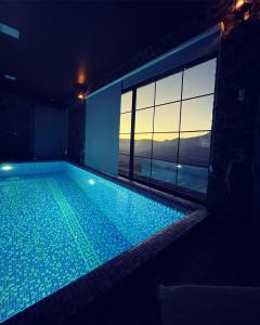 a large swimming pool in a room with a window at Premium VILLA (LUXURY Mansion) in Şamaxı