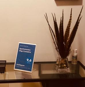 a sign on a table with a vase with a plant at Apartamentos Olga Cantabria in Polanco