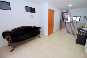 sala de estar con sofá negro y nevera en Apartahotel La Villa Santa fe de Antioquia, en Santa Fe de Antioquia