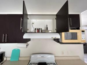 uma cozinha com armários a preto e branco e um fogão em Relajante casa con alberca & auto check-in em Mazatlán