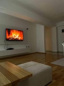 a living room with a fireplace on the wall at Golden Apartment in Skopje