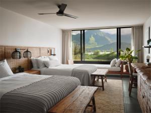 a hotel room with two beds and a large window at 1 Hotel Hanalei Bay in Princeville
