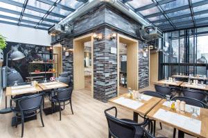 a restaurant with wooden tables and chairs and a brick wall at Smart Hotel in Gdańsk
