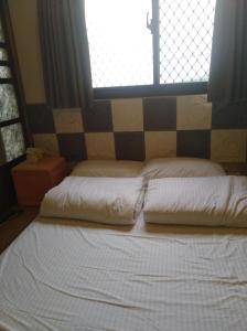 a bed with two pillows in front of a window at 路邊望海 in Jiufen