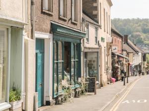 eine Straße in einer Altstadt mit Tischen und Stühlen in der Unterkunft Thomas Cottage in Wotton under Edge