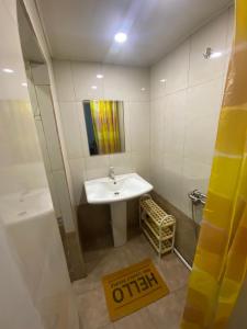 uma casa de banho com um lavatório e um chuveiro e um sinal de precaução em Shirakatsi Guest House em Guiumri