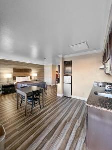 a room with a bed and a table and a kitchen at Rodeo Lodge in Clovis