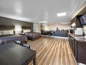 une chambre d'hôtel avec deux lits et une cuisine dans l'établissement Rodeo Lodge, à Clovis