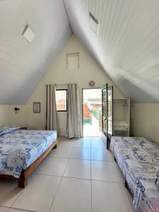 two beds in a room with a attic at Águas Chalés Temporada - Chalés e Lofts Confortáveis - Piscina - Próximo ao Thermas in Águas de São Pedro
