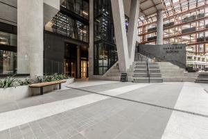 a lobby of a building with a staircase in front at KULA South Yarra in Melbourne
