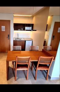 a large wooden table with chairs and a kitchen at Salinas Premium Resort in Salinópolis