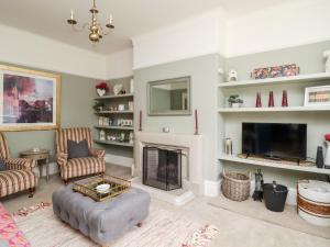 a living room with a fireplace and a tv at The Kingsway in Ilkley