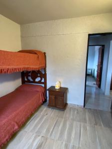 Un dormitorio con una cama y una mesa con una vela en Departamento 2 dormitorios Villa Carlos Paz en Villa Carlos Paz