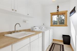 eine weiße Küche mit Spüle und Fenster in der Unterkunft Cozy Lakeview Hideaway by Big Bear Vacations Amazing Fawnskin Log Cabin Chalet in Fawnskin + 39 Fotos