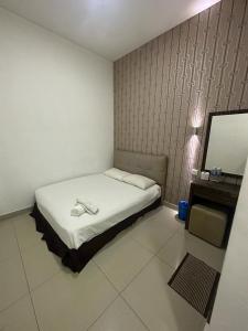 One Point Hotel @ Airport (Kuching) في كوتشينغ: غرفه فيها سرير وتلفزيون
