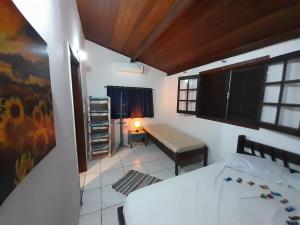 1 dormitorio con cama, escritorio y ventana en Chales Sea Sul, en Ilhabela