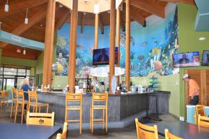 un restaurante con un bar con un mural de pescado en Ocean front condo, en Panama City Beach