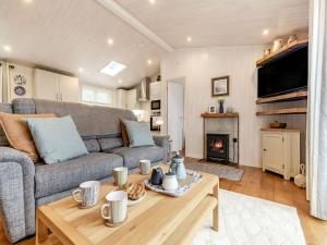 a living room with a couch and a table at Rosemary Lodge in Willington