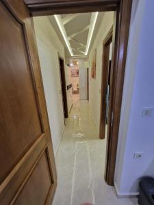 un couloir avec une porte en bois dans un bâtiment dans l'établissement Fabuleux Appart a Larache avec confort exceptionnel et propreté souhaitée, à Larache