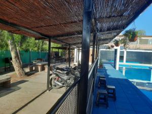 Ein Motorrad, das unter einem Dach neben einem Swimmingpool geparkt ist in der Unterkunft Apart Hotel Chilecito in Chilecito