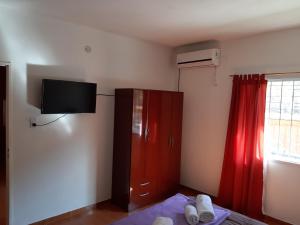 a bedroom with a red cabinet and a red curtain at Apart Hotel Chilecito in Chilecito