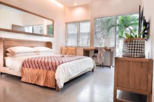 sypialnia z łóżkiem i dużym lustrem w obiekcie Seruni Guest House w mieście Denpasar