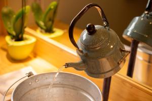 a tea kettle is pouring water into a pot at Coffee Pickers Village By Hacienda Orosi in Cartago