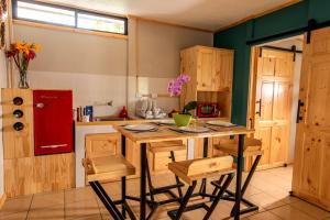 a kitchen with a wooden table and some chairs at Coffee Pickers Village By Hacienda Orosi in Cartago