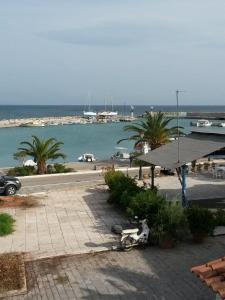 a scooter parked on a sidewalk next to a body of water at Drakopanagiotaki Rooms in Agios Andreas
