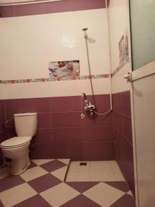 a bathroom with a toilet and a tile floor at JERDOUH For FAMILY ONLY in Tétouan