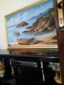 a painting of a boat sitting on top of a table at JERDOUH For FAMILY ONLY in Tetouan
