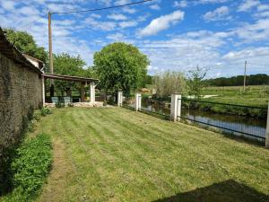 un patio con una valla junto a un cuerpo de agua en Gîte Saint-Sulpice-de-Cognac, 3 pièces, 4 personnes - FR-1-653-221, en Saint-Sulpice-de-Cognac