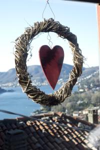 ein Herz hängt von einem Kranz auf einem Dach in der Unterkunft Casa Rossa - byMyHomeinComo in Cernobbio